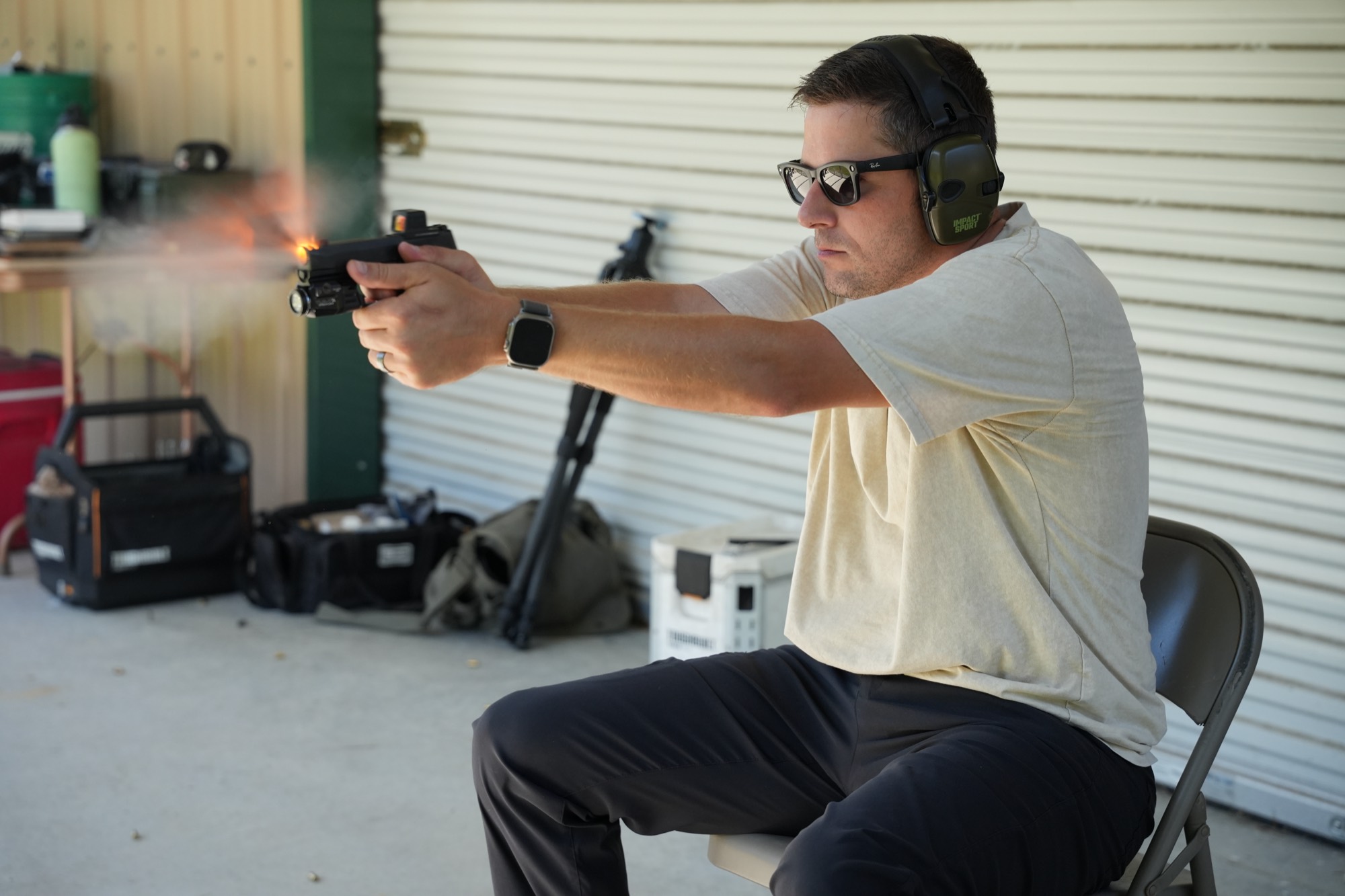 Kenny Siddons firing a pistol at the range, wearing eye and ear protection